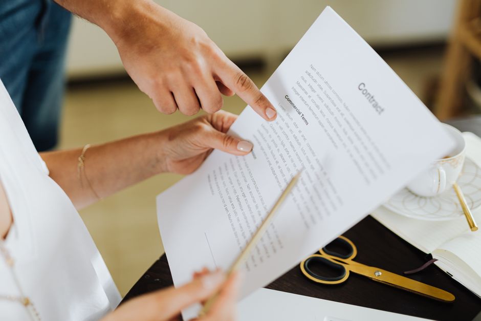 Pessoa assinando um contrato de negócios, simbolizando parcerias ou acordos empresariais.