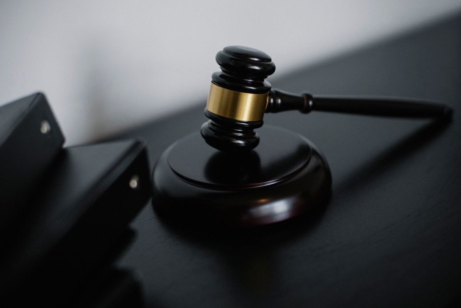 Imagem de um martelo de juiz sobre uma bancada, simbolizando justiça e decisão judicial.