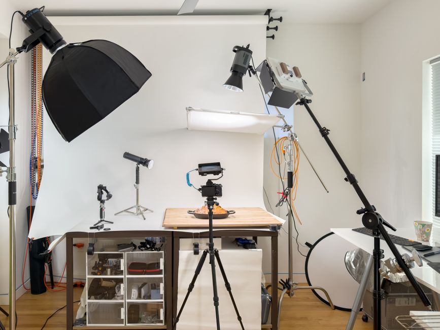 Espaço de produção audiovisual equipado com iluminação e câmeras para filmagens profissionais.