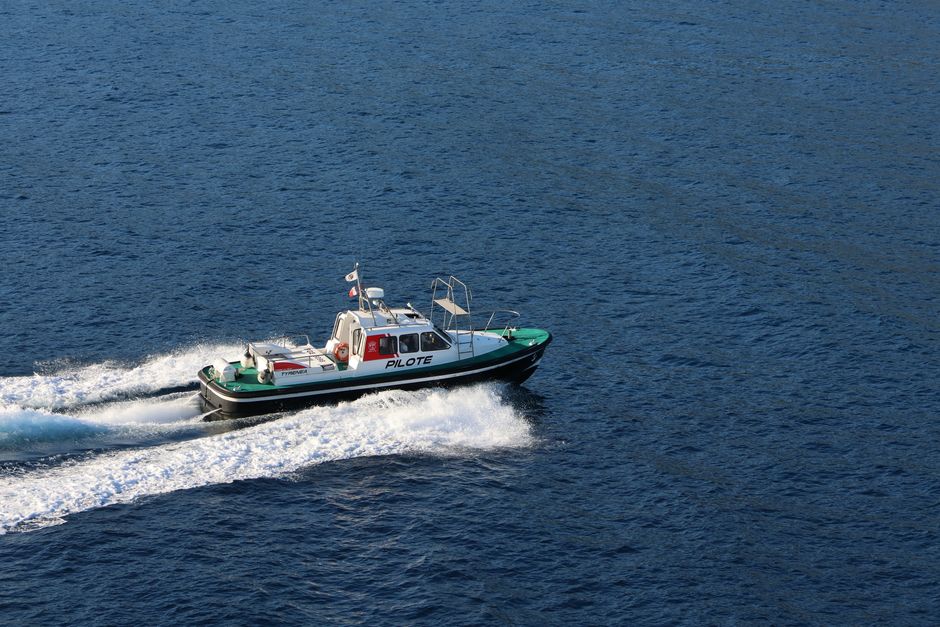 Imagem de uma embarcação de piloto marítimo navegando pelo mar, representando segurança e expertise na navegação marítima.