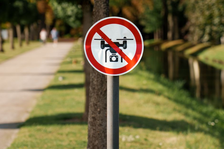 Placa de sinalização indicando a proibição de drones em áreas públicas ao ar livre.