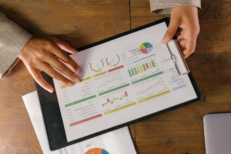 Pessoa analisando gráficos e relatórios financeiros em um tablet, simbolizando tomada de decisões estratégicas.