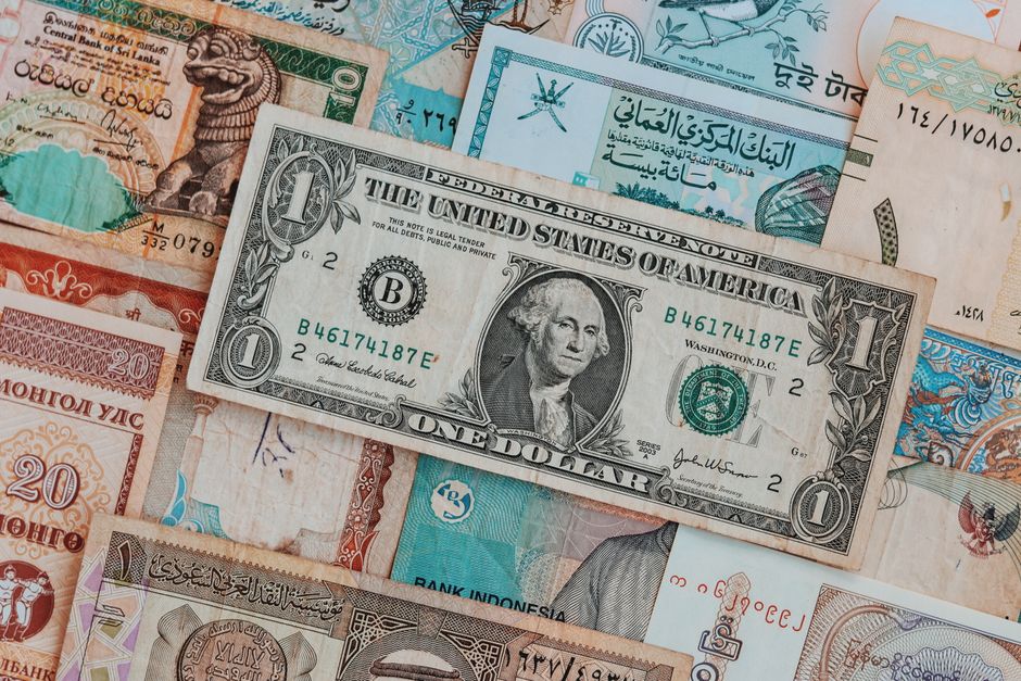 Imagem de várias moedas e cédulas de diferentes países, simbolizando economia e finanças globais.