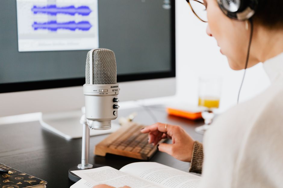 Pessoa gravando podcast de temática educacional ou científica, com foco na comunicação e transmissão de conhecimento.