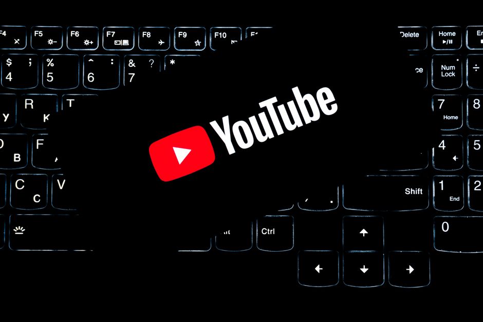 Imagem de um teclado de computador com o logotipo do YouTube destacado ao centro, representando a criação e o consumo de conteúdos em vídeos na plataforma.
