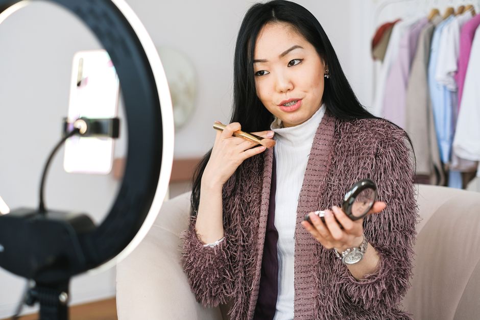 Mulher fazendo uma apresentação de beleza ou moda em uma gravação de vídeo para blog ou canal digital.