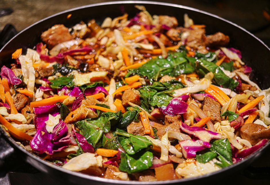 Imagem de um prato colorido com vegetais variados e pedaços de carne, pronto para servir como refeição nutritiva e saborosa.
