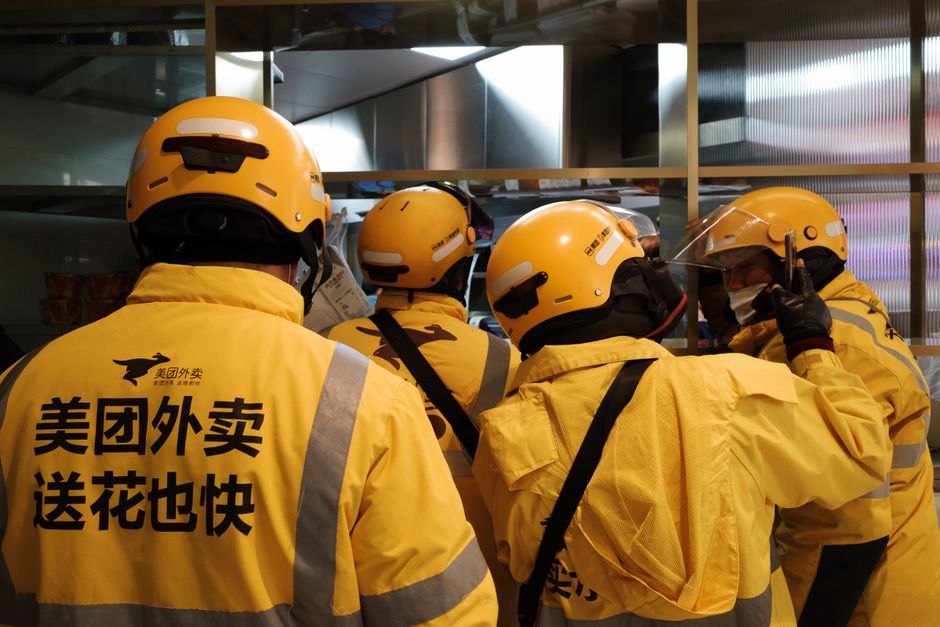 Equipe de entregadores da Meituan Fantuan reunidos, prontos para realizar entregas emérgicas, destacando a logística e a mobilidade urbana na cidade