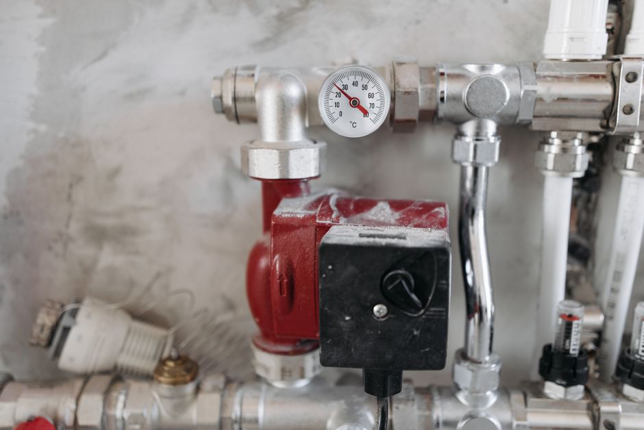 Imagem de um sistema de válvulas e termômetros em instalação industrial, destacando componentes de controle de temperatura e fluxo de líquidos ou gases.