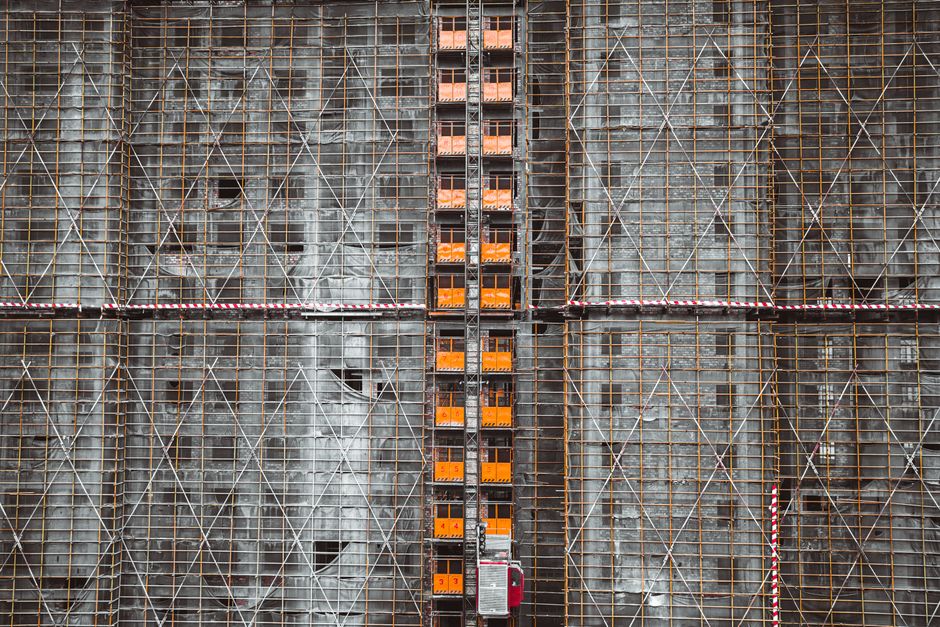 Imagem de uma construção civil em andamento, focalizando a estrutura de andaimes e escavações, representando o tema de construção e engenharia.
