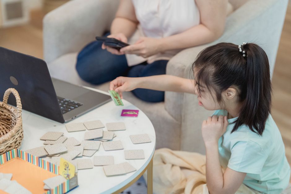 Momento de lazer em família jogando jogos de memória enquanto usa dispositivos eletrônicos.