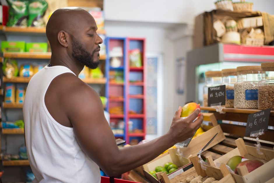 Homem fazendo compras de frutas e alimentos naturais em uma feira ou supermercado