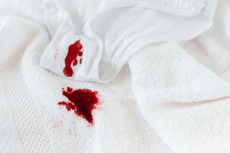 Imagem que sugere uma situação de emergência ou acidente, com sangue e roupas de cama brancas.