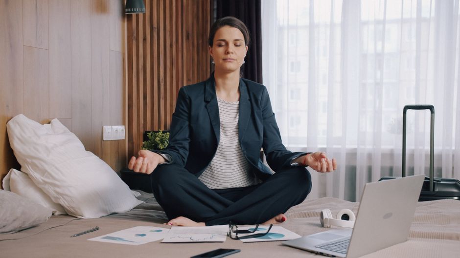 Mulher praticando meditação em um ambiente de trabalho doméstico, promovendo bem-estar e equilíbrio entre vida profissional e pessoal.