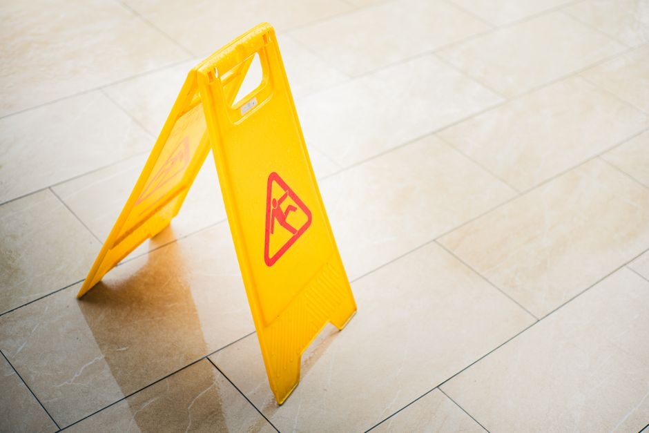 Sinal de aviso de piso molhado em um ambiente interno, indicando cuidados com a segurança