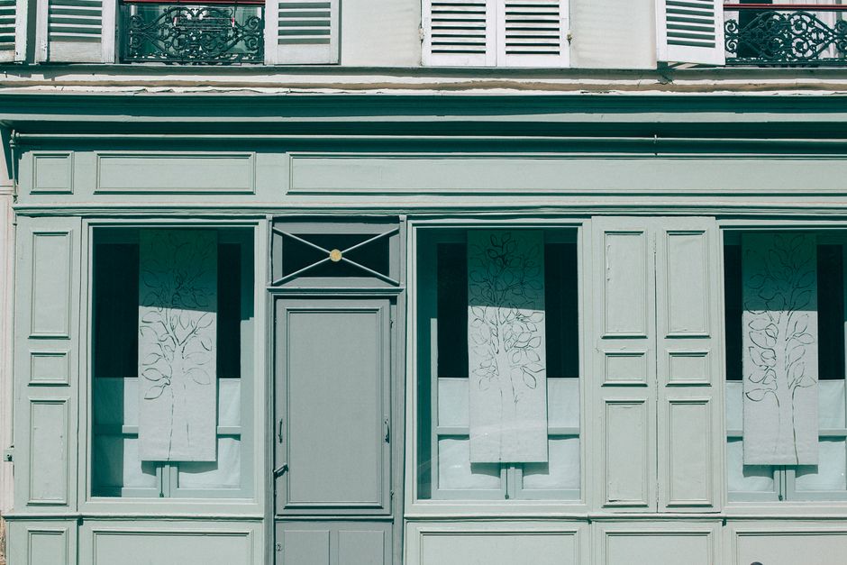 Imagem de um edifício com fachada clássica, com detalhes arquitetônicos sofisticados e janelas decoradas, transmitindo elegância e charme urbano.