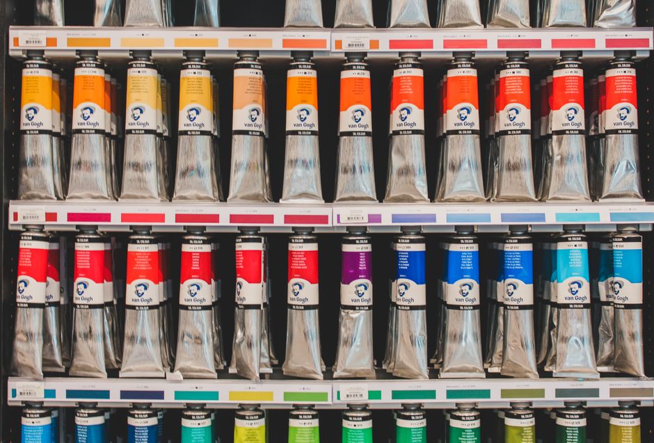 Telas de tinta de diferentes cores organizadas em uma prateleira, representando materiais para pintura ou impressão.