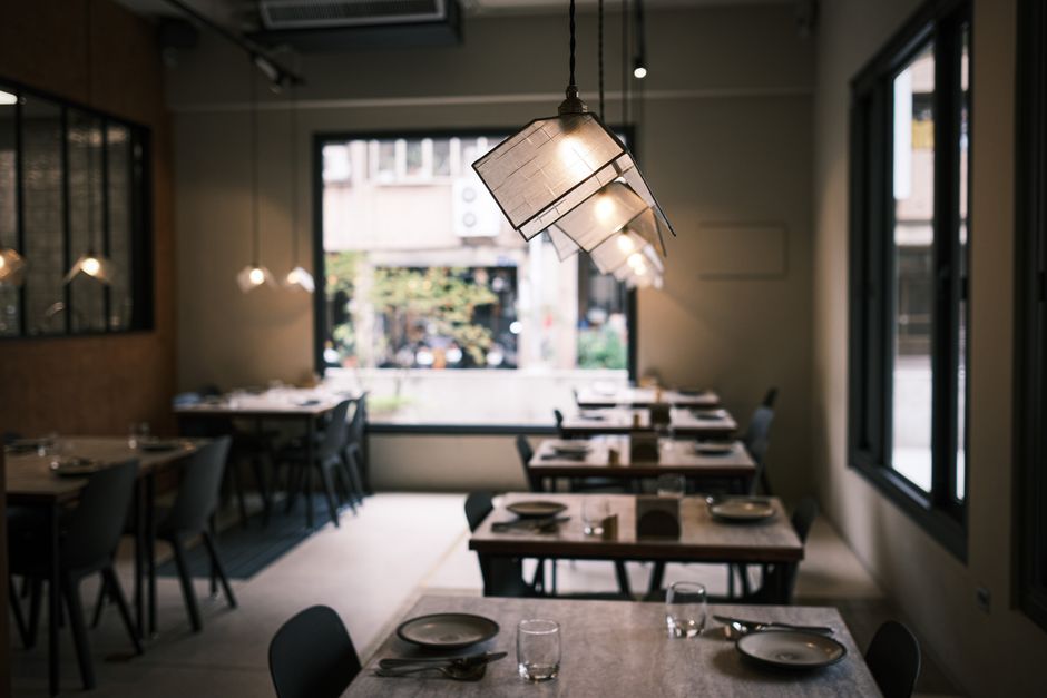 Ambiente de restaurante elegante com iluminação moderna e mesas preparadas para atender clientes, ideal para artigos sobre gastronomia, experiência gastronômica, decoração de restaurantes ou hospitalidade.