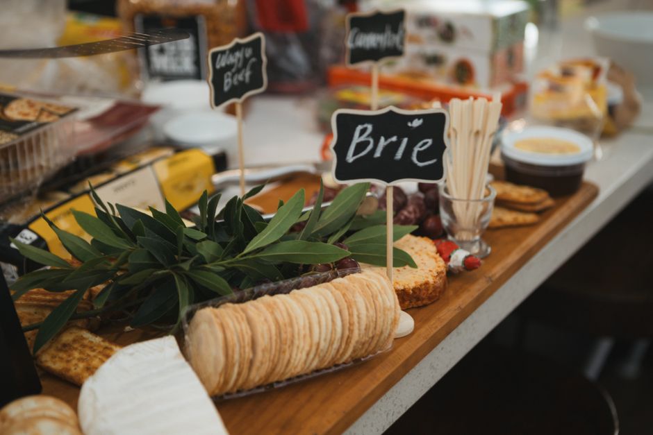 Mesa de queijos e petiscos variados com etiquetas de identificação, ideal para uma degustação ou evento gourmet.