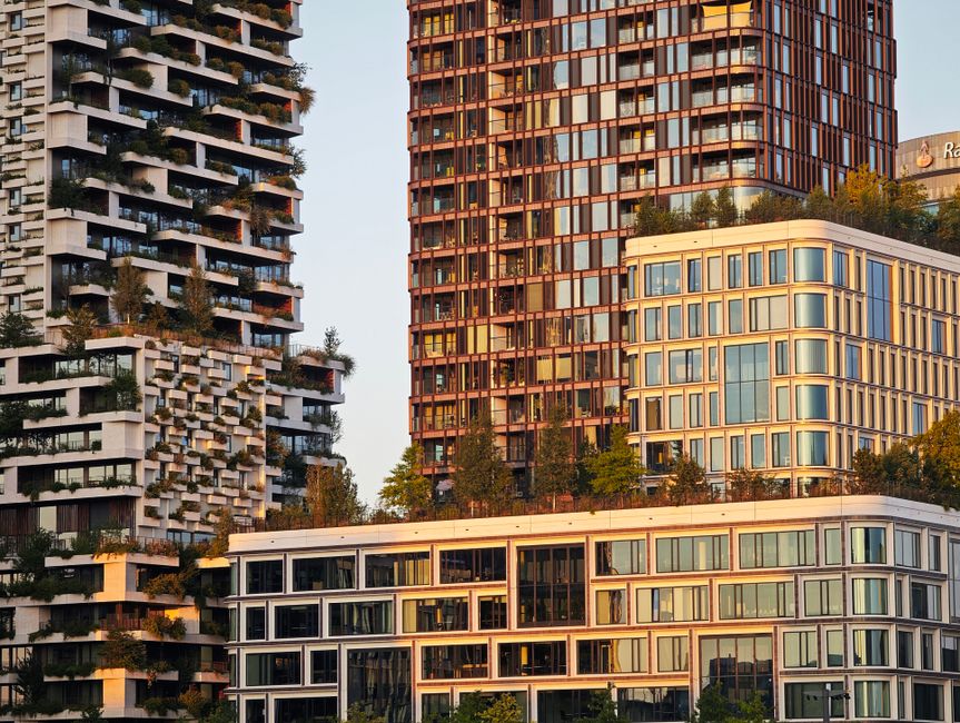 Imagem de edifícios modernos e sustentáveis em um ambiente urbano, destacando arquitetura contemporânea e integração com a natureza.