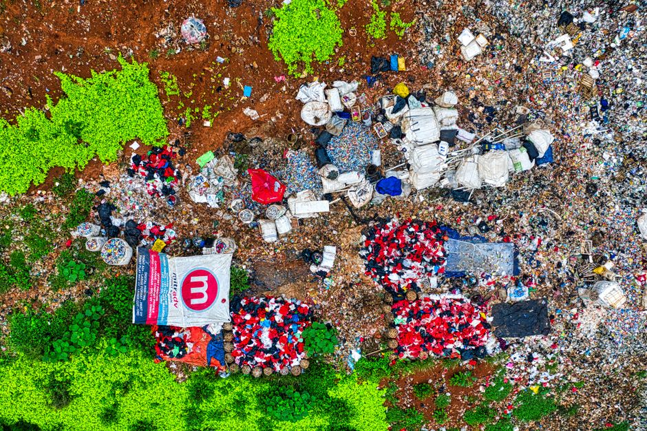 Imagem aérea de um lixão com resíduos e lixo espalhado, destacando problemas ambientais relacionados ao descarte inadequado de resíduos sólidos.