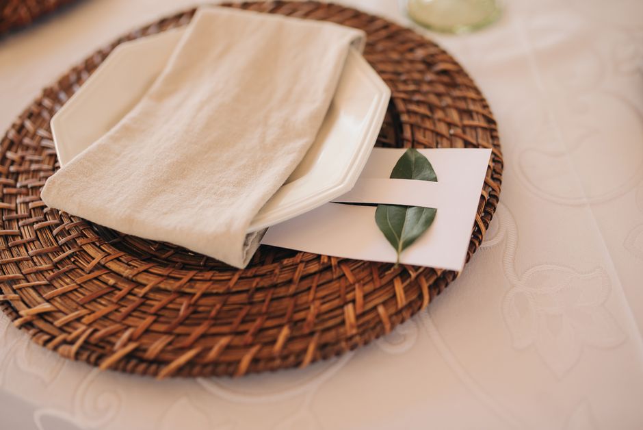 Uma mesa de jantar decorada com elegância, destacando detalhes de paleta de cores neutras e elementos naturais para criar um ambiente acolhedor e sofisticado.