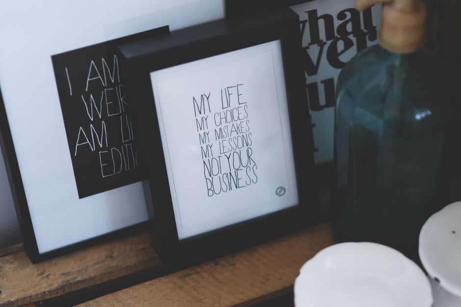 Quadro decorativo com mensagem sobre autoconhecimento e empreendedorismo em um ambiente de trabalho ou escritório.