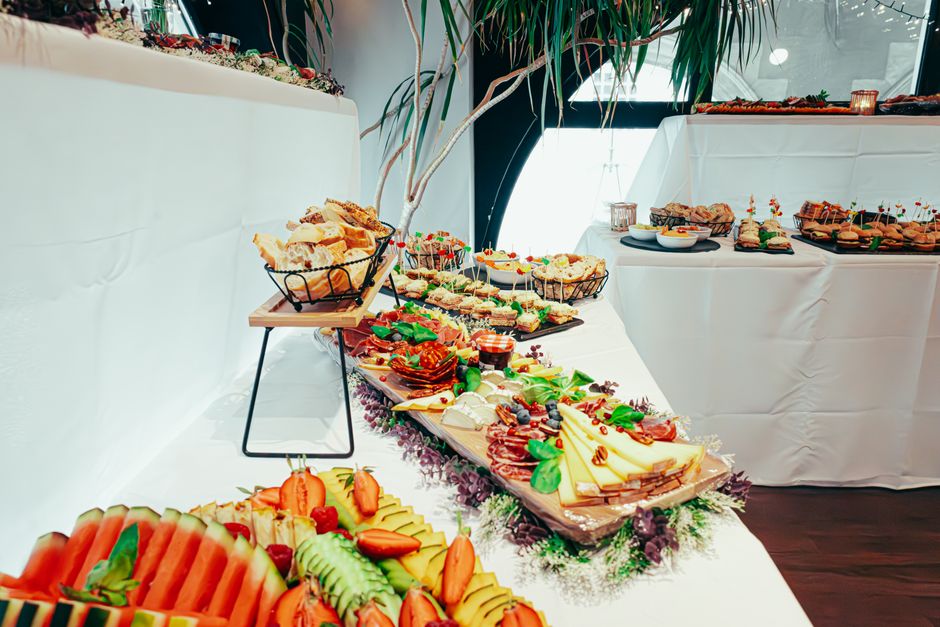 Mesa de buffet com diversas opções de alimentos em um evento social ou empresarial.