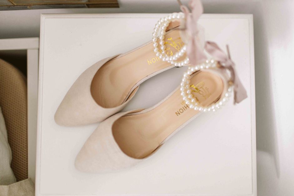 Sapatos femininos delicados de salto alto decorados com pérola, ideal para looks elegantes e ocasiões especiais.