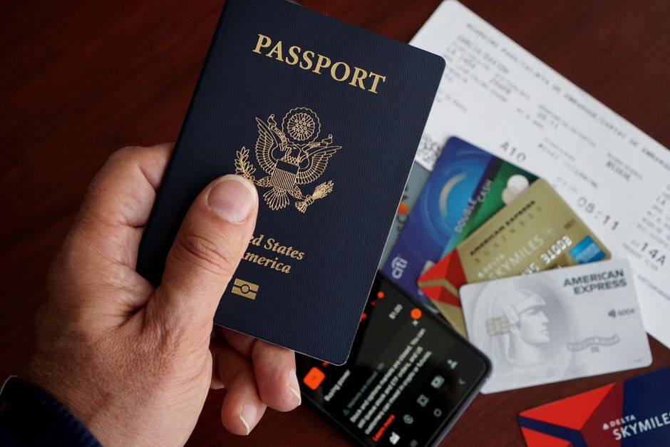 Imagem de um passaporte dos Estados Unidos rodeado por cartões de crédito e documentos de viagem, simbolizando planejamento e organização para viagens internacionais.