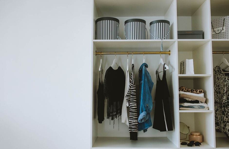 Armário organizado com roupas, acessórios e caixas de armazenamento, ideal para mostrar dicas de organização de closet.
