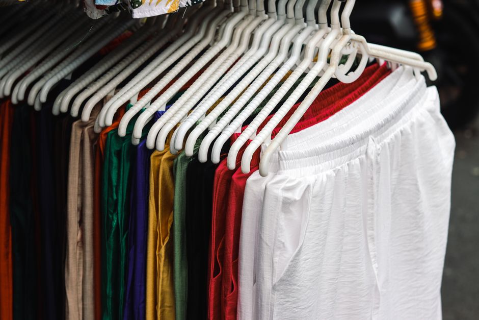 Conjunto de roupas esportivas coloridas organizadas em cabide, perfeito para destaque em uma loja de roupas ou artigo sobre moda fitness.