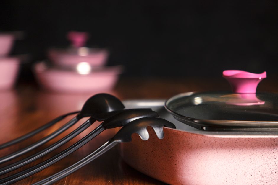 Conjunto de utensílios de cozinha em cerâmica e silicone, pronto para preparar uma refeição caseira com foco em culinária e gastronomia.
