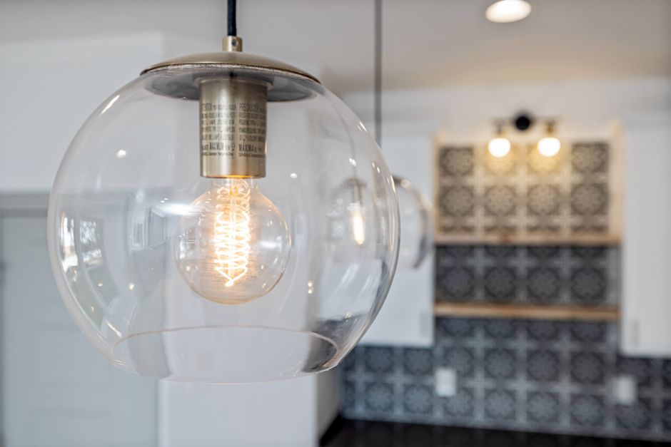 Lâmpada de luz quente pendurada no teto, criando uma atmosfera moderna e aconchegante em um ambiente interno de design contemporâneo.