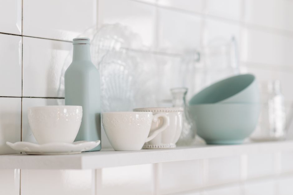 Imagem de uma prateleira com louças de cozinha em tom pastel, criando um ambiente clean e organizado para fotos de culinária ou decoração de interiores.