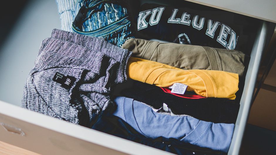 Imagem de roupas organizadas em uma gaveta, representando organização e rotina diária.