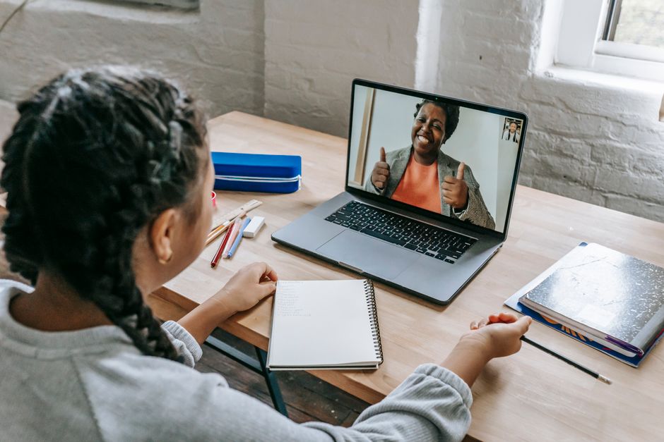 Juventude participando de uma videochamada com uma professora ou mentora, promovendo educação à distância ou aprendizagem online.