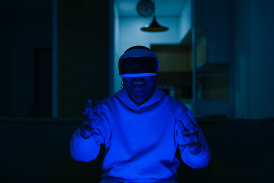 Pessoa usando óculos de realidade virtual em ambiente doméstico, demonstrando entusiasmo e interação digital.