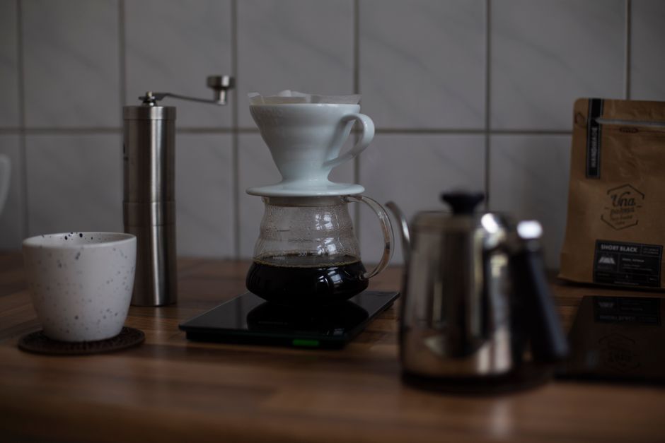Imagem de uma preparação de café coado em um ambiente de cozinha, com foco na técnica de filtragem manual.