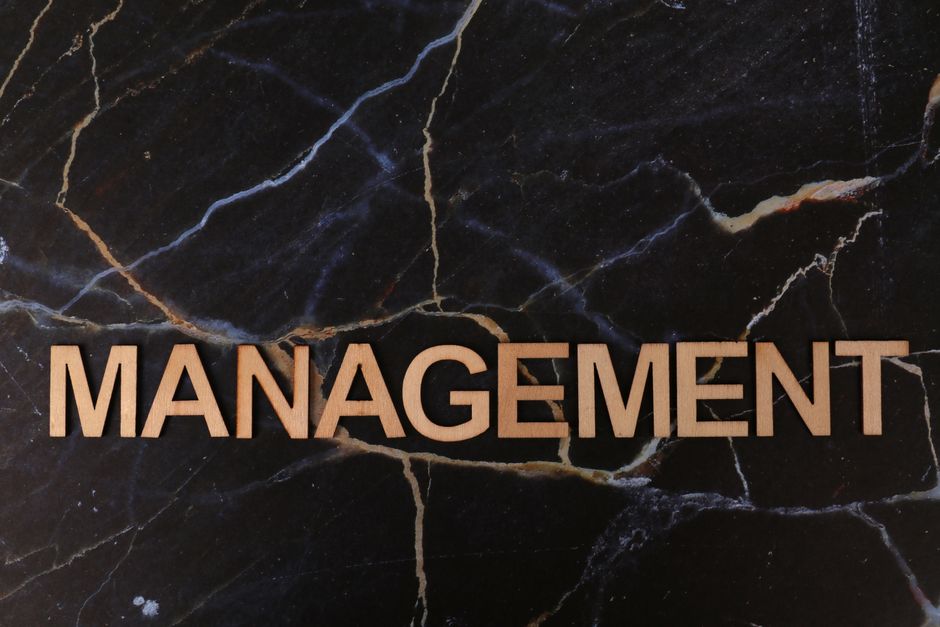 Imagem de uma placa com a palavra 'Management' em destaque, representando temas relacionados à administração e gestão empresarial.