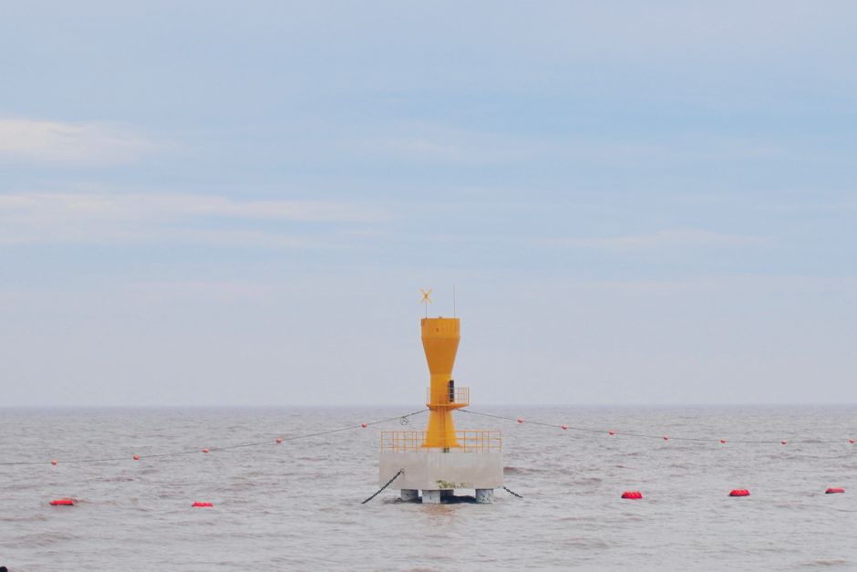 Imagem de um farol amarelo no mar, simbolizando orientação e segurança na navegação marítima.