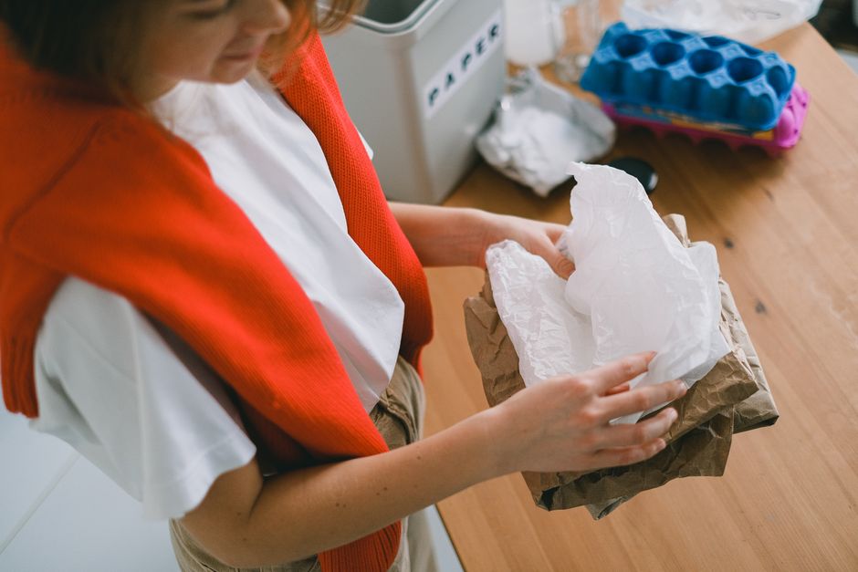 Pessoa segurando papel absorvente, possivelmente em um ambiente de cozinha ou laboratório doméstico.