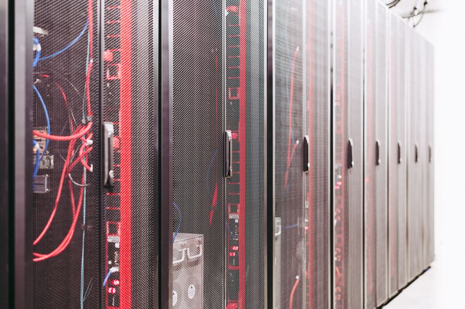 Imagem de um data center com servidores alinhados em racks, destacando a infraestrutura de tecnologia e armazenamento de dados.