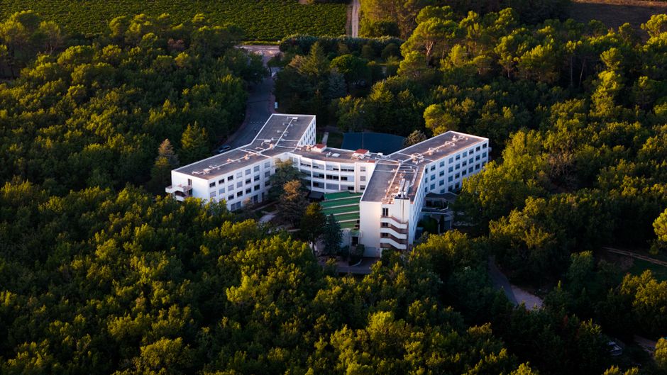 Edifício moderno de desenho inovador cercado por uma vasta área de floresta, em um ambiente tranquilo e sustentável.