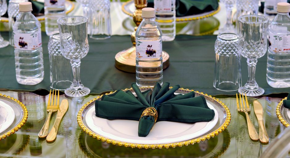 Mesa decorada para uma celebração formal com pratos sofisticados e detalhes elegantes na composição da mesa.