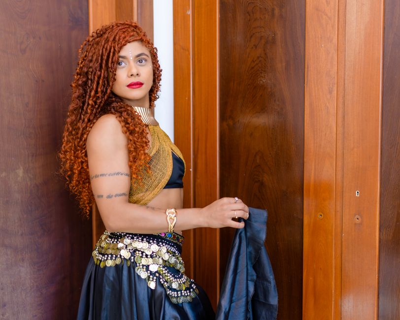 Mulher com fantasia de dança do ventre, destacando a cultura e tradição nas apresentações artísticas.