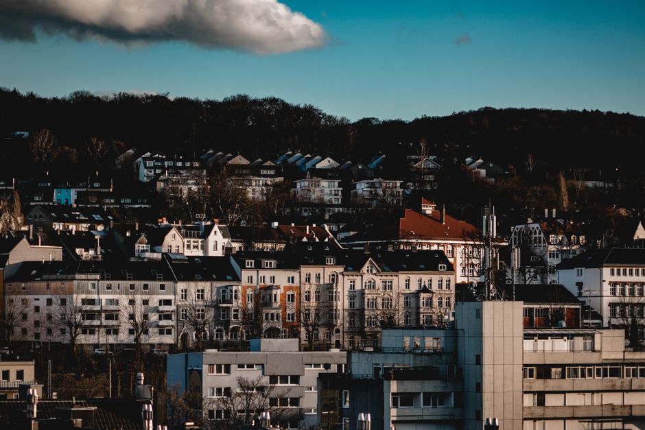 Vista panorâmica de uma cidade com prédios residenciais e comerciais, destacando a harmonia entre urbanismo e natureza ao fundo.