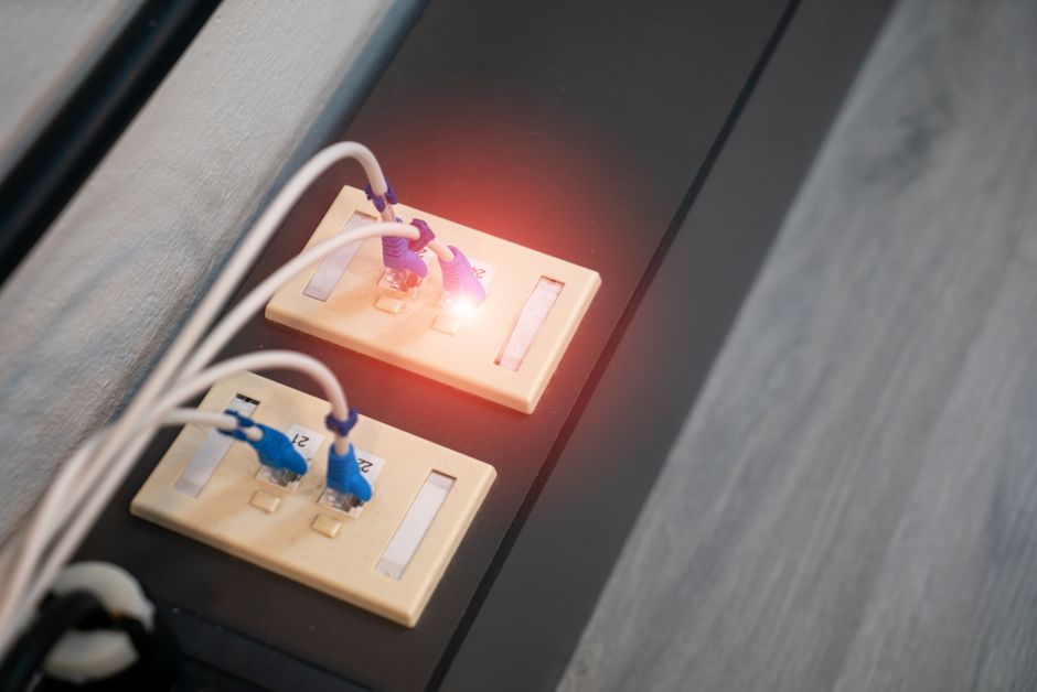 Imagem ilustrativa de testes de energia elétrica em uma tomada, destacando a importância da segurança elétrica em ambientes residenciais e comerciais.