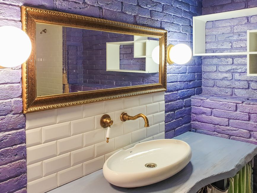 Banheiro com decoração moderna e iluminação suave, combinando elementos clássicos e contemporâneos.