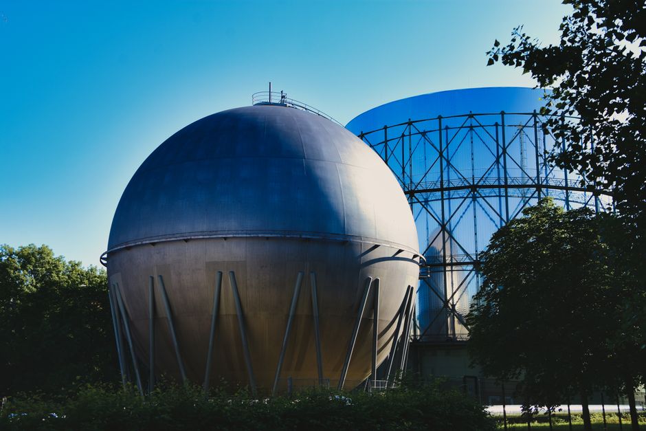 Imagem de uma usina de energia nuclear com suas estruturas metálicas e cúpula, destacando o tema de fontes de energia sustentável ou nuclear.